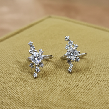 Pair of diamond earrings on a textured gold surface