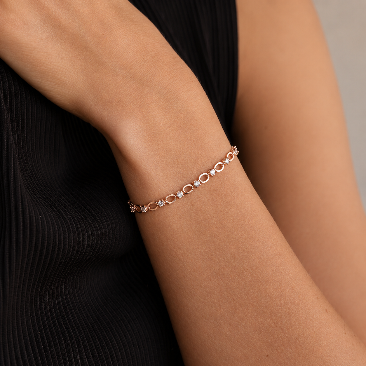 Rose gold bracelet on a person's wrist with a neutral background
