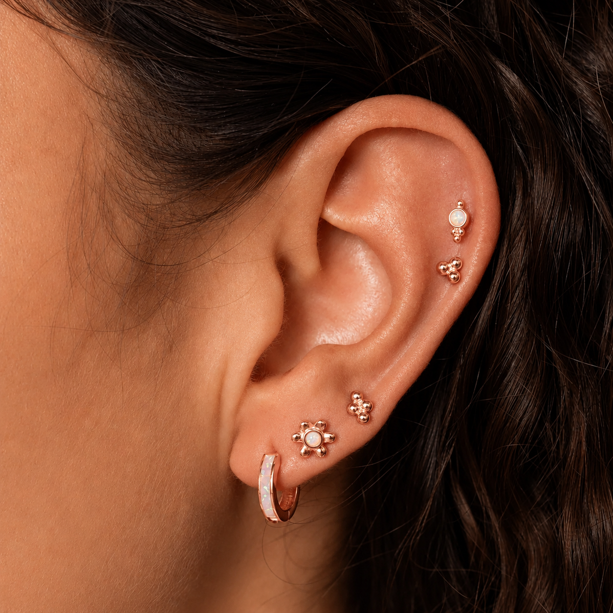 Close-up of an ear with multiple gold earrings