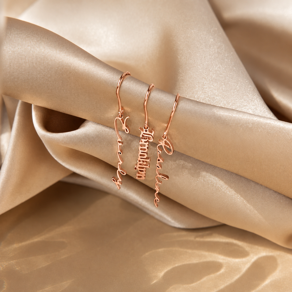 Rose gold name bracelets on beige fabric