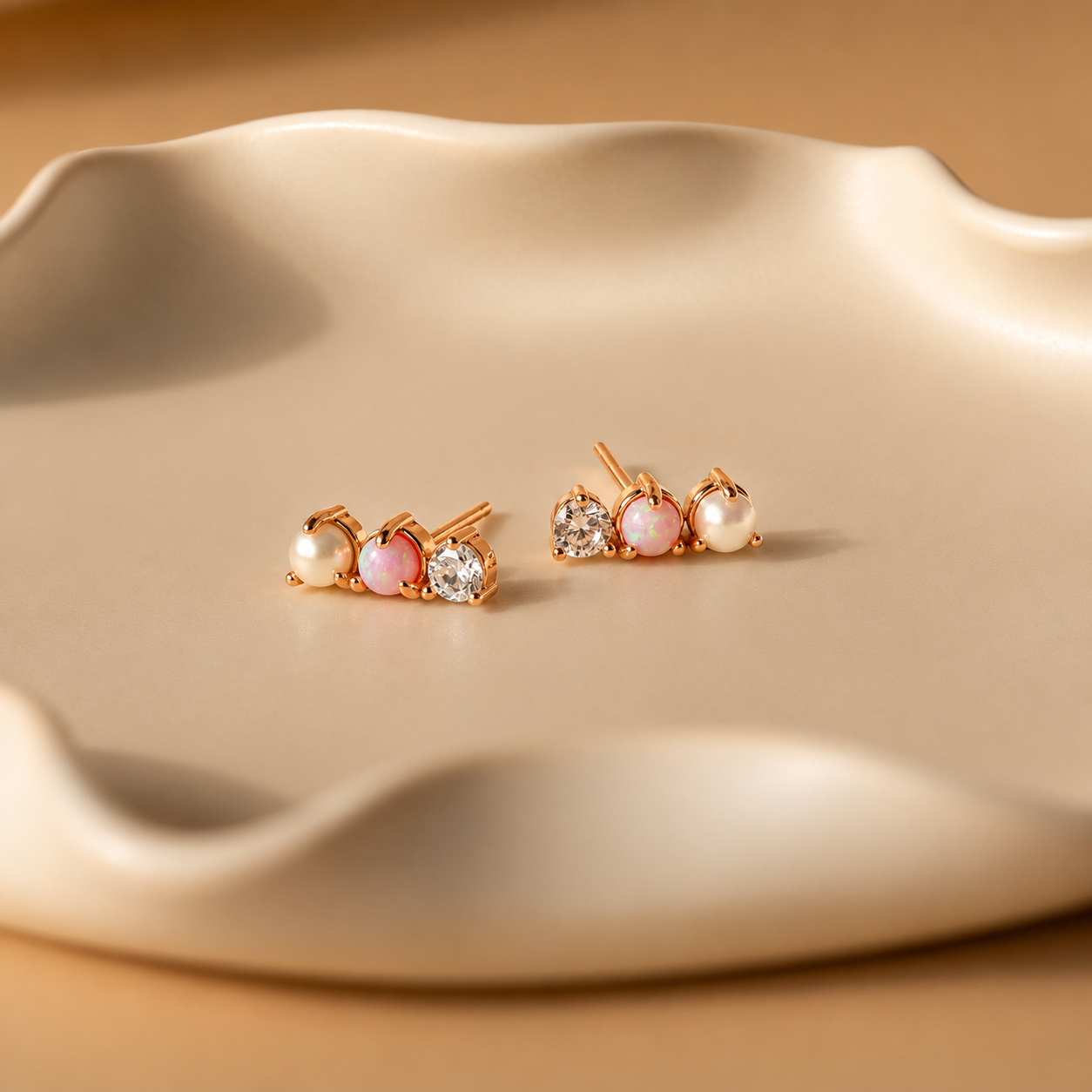 Pair of pearl and gemstone earrings on a beige surface
