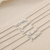 Silver name necklaces on a beige background