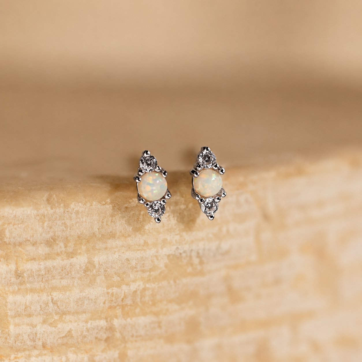 Pair of opal earrings on a wooden surface