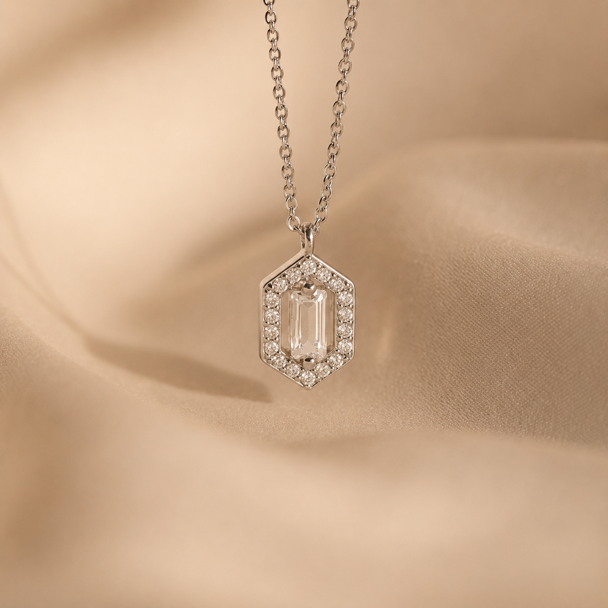 Diamond necklace with a hexagonal pendant on a beige fabric background
