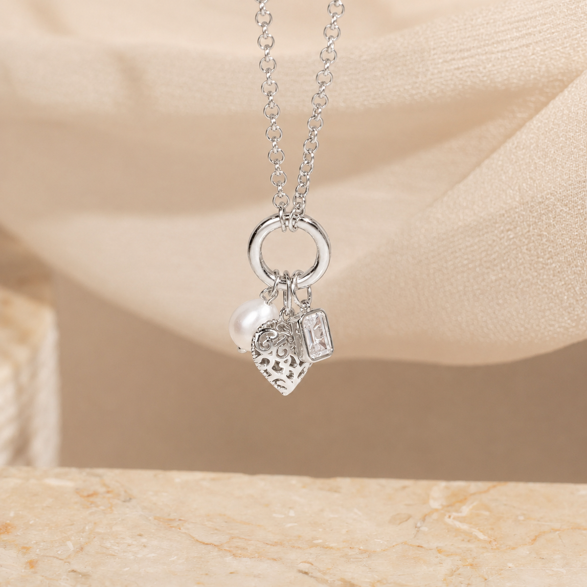 Silver necklace with charms on a beige background