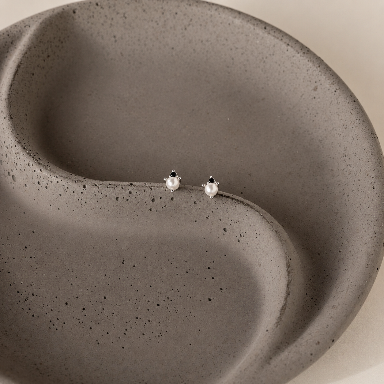 Pair of earrings on a textured gray surface