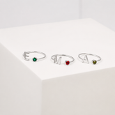 Three silver rings with gemstones on a white background