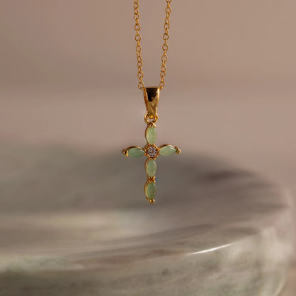 Serenity Jade Cross Necklace displayed elegantly on a neutral background, highlighting the soothing green jade and polished silver finish.
