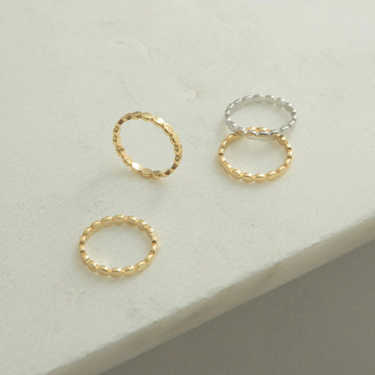 Three gold rings on a light gray surface