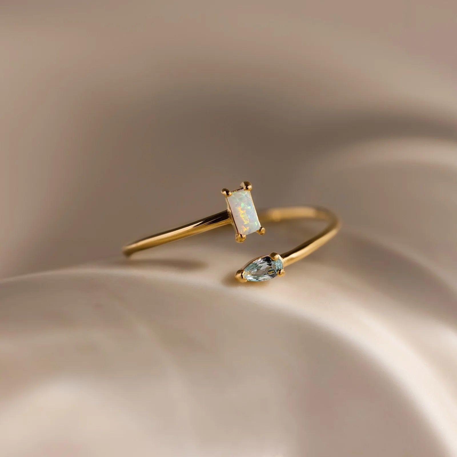 Gold ring with gemstones on a beige background
