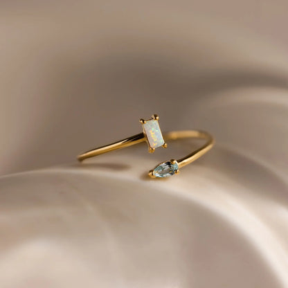 Gold ring with gemstones on a beige background