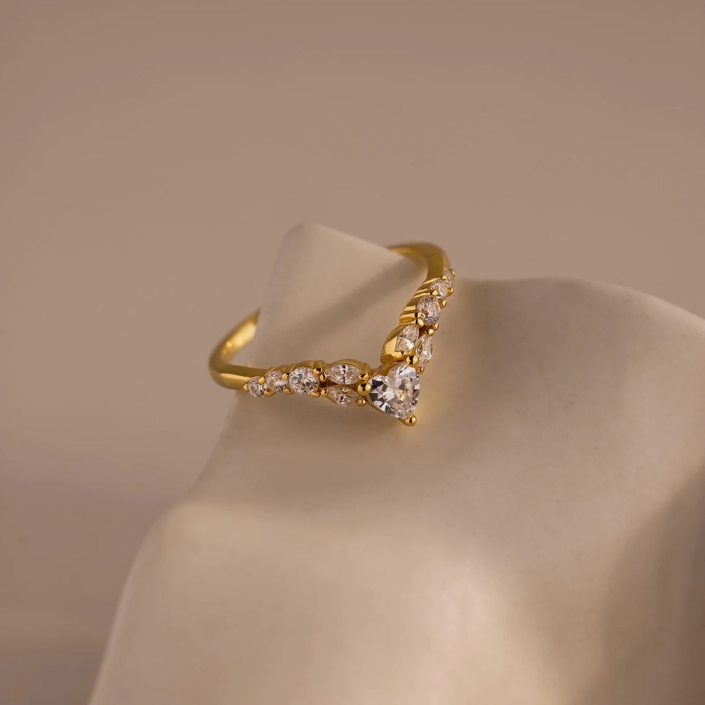 Gold ring with diamonds on a beige background