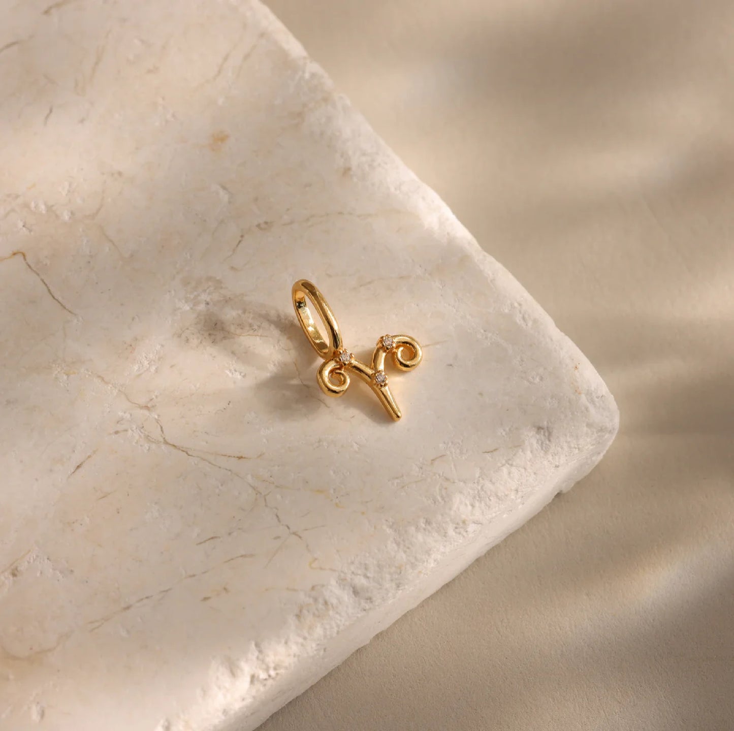 Gold pendant with a design on a marble surface