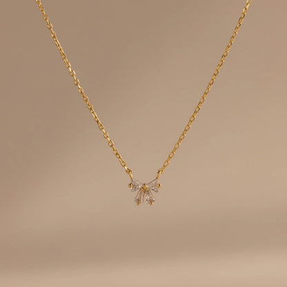 Gold necklace with a delicate pendant on a beige background