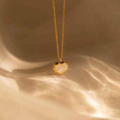 Gold heart-shaped pendant necklace on a gold background