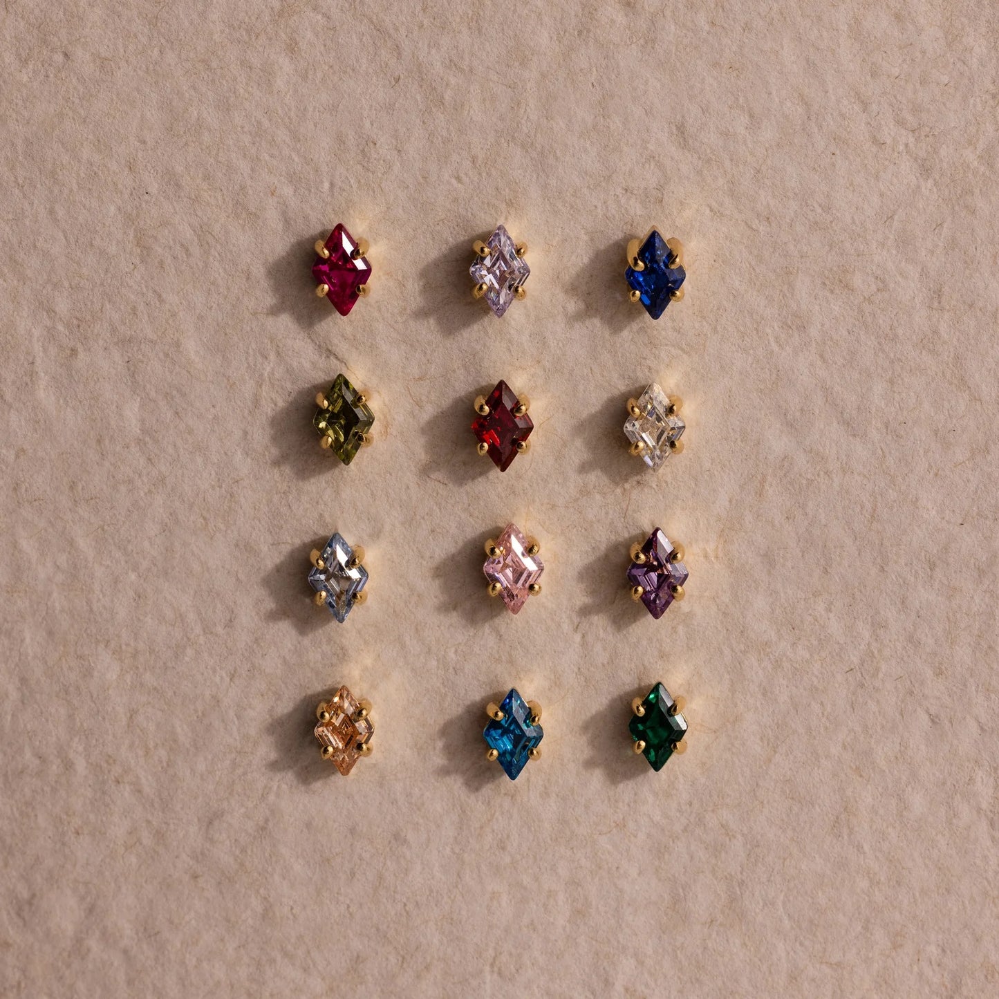 Assorted colorful gemstone earrings on a beige background