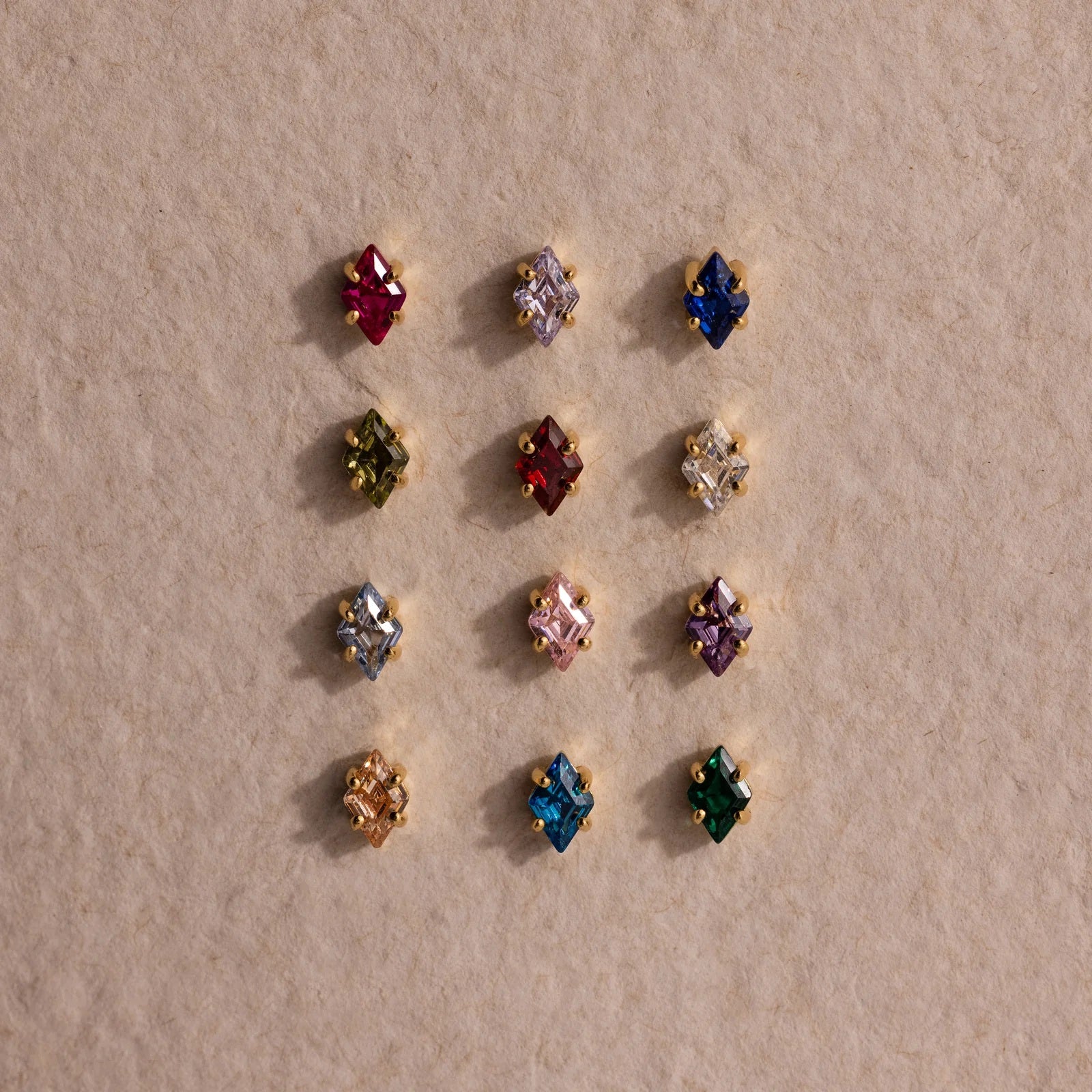 Assorted colorful gemstone earrings on a beige background