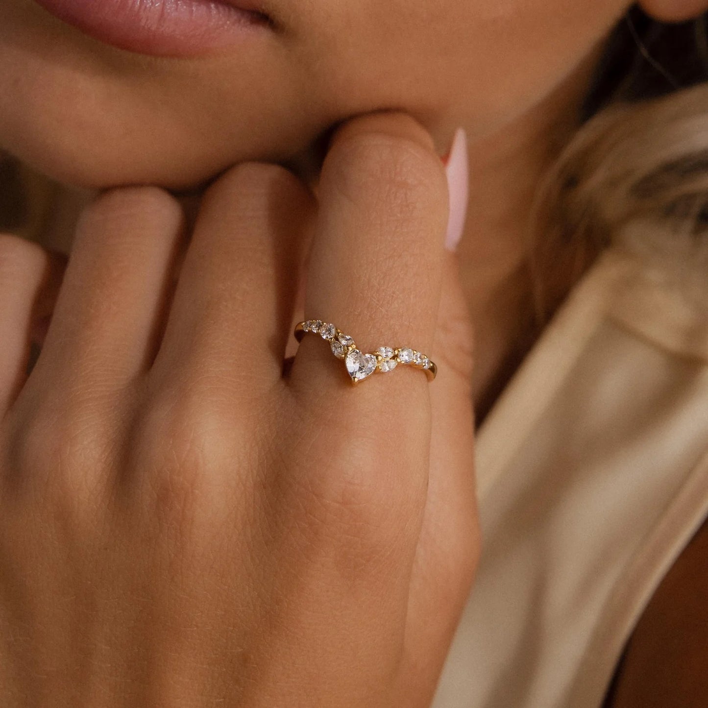 Close-up of a hand wearing a diamond ring with a blurred background