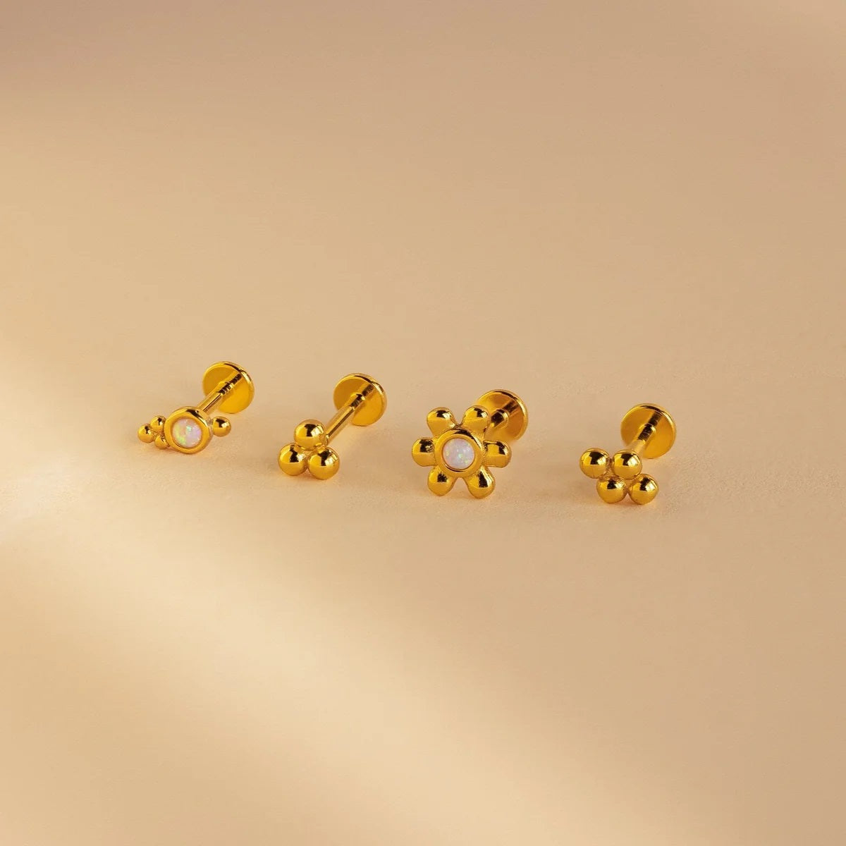 Set of gold earrings on a beige background