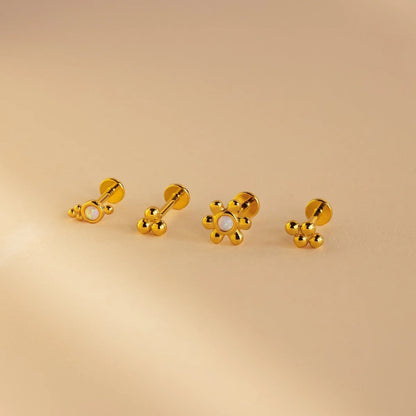 Set of gold earrings on a beige background