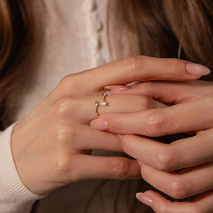 Close-up of hands with a ring on a neutral background