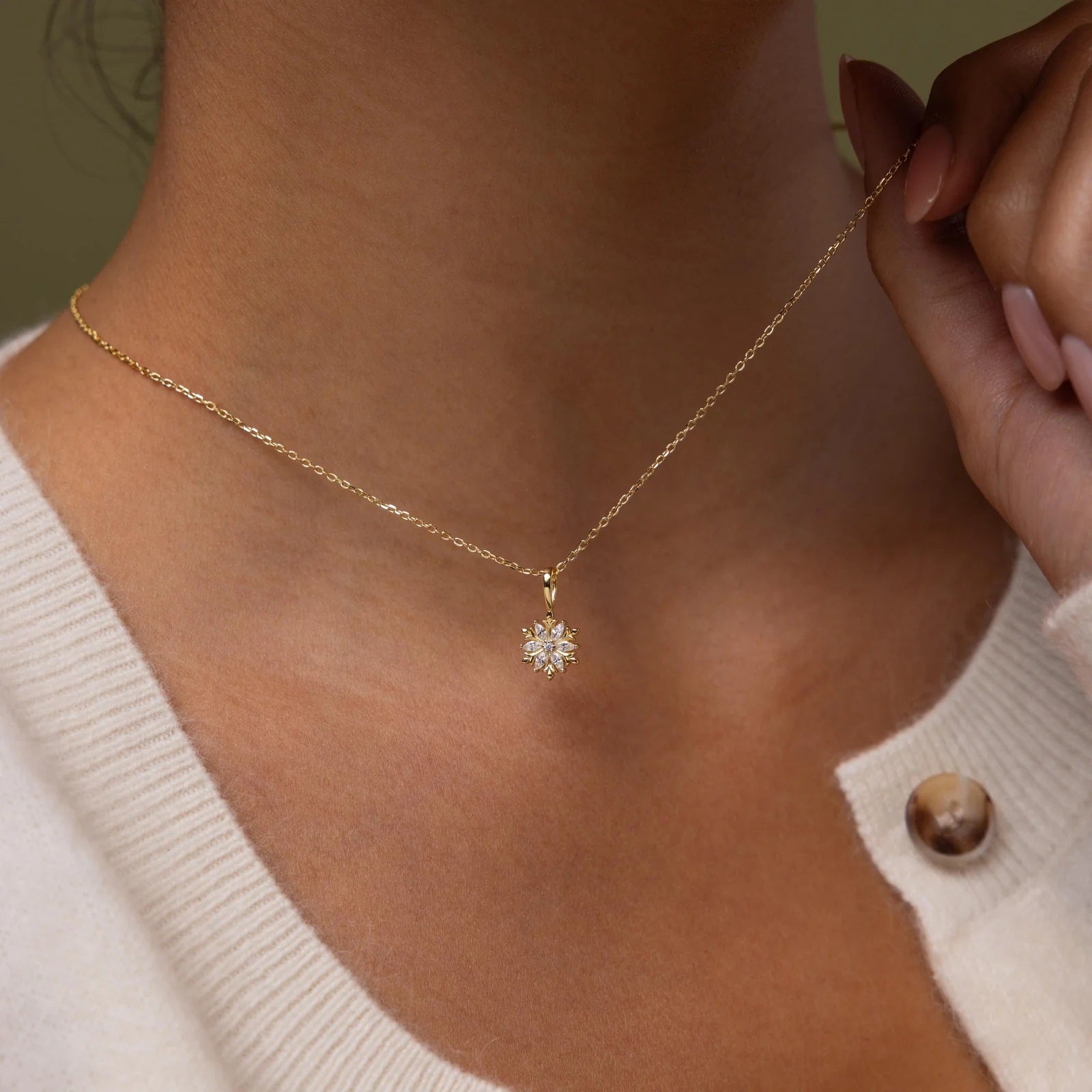 Gold necklace with a diamond pendant worn by a person