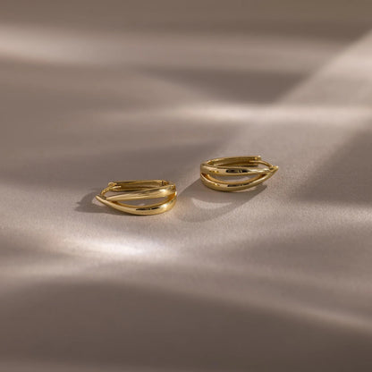 Two gold rings on a beige fabric background