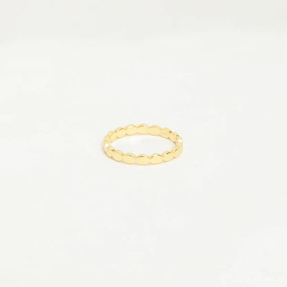 Gold ring on a light beige background