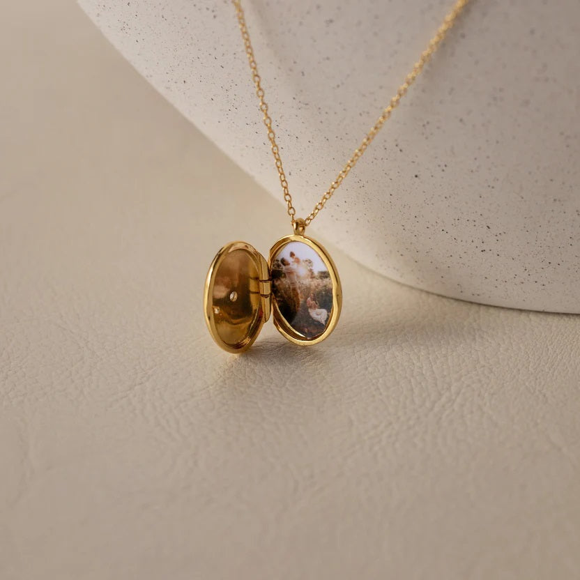 Gold locket necklace on a beige background