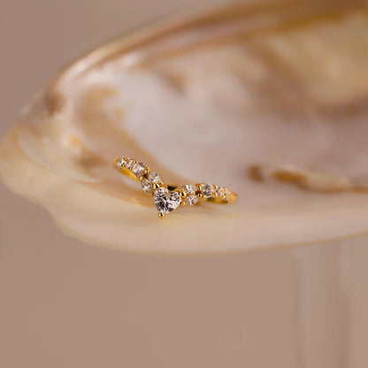 Gold ring with small diamonds on a beige shell background