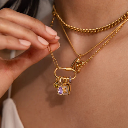 Gold necklace with charms being adjusted on a person's neck