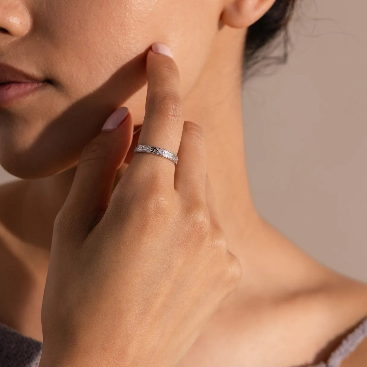 Woman touching her face with a neutral background