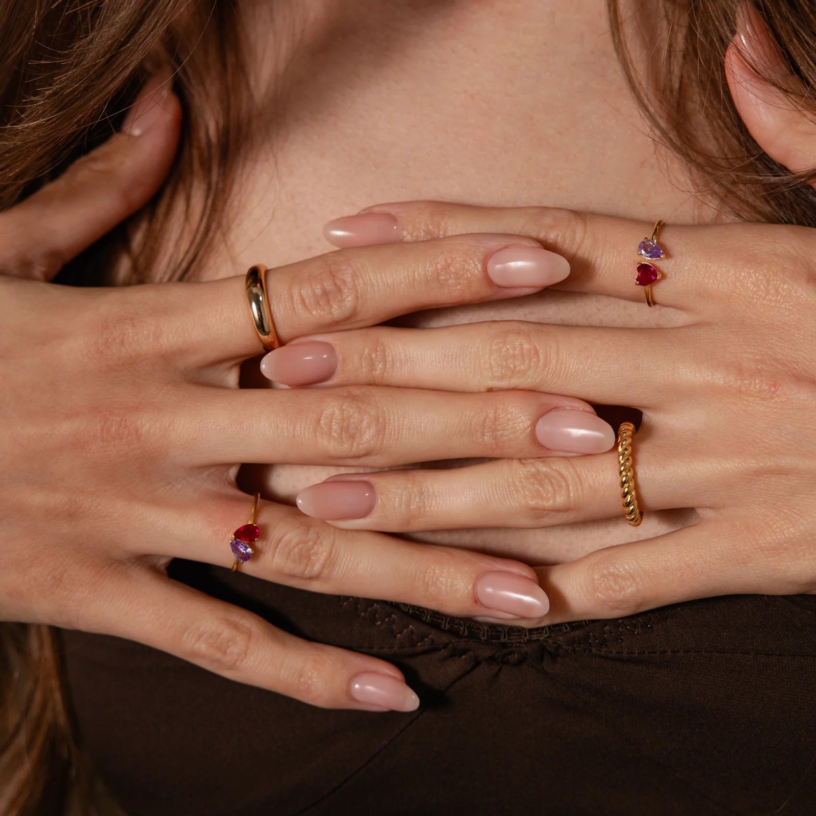 Close-up of hands with rings on fingers, covering face