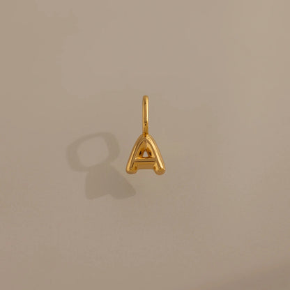 Gold letter 'A' pendant on a beige background