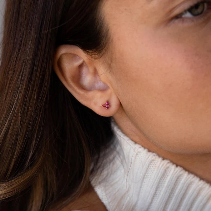 Close-up of a woman wearing pink earrings with a neutral background