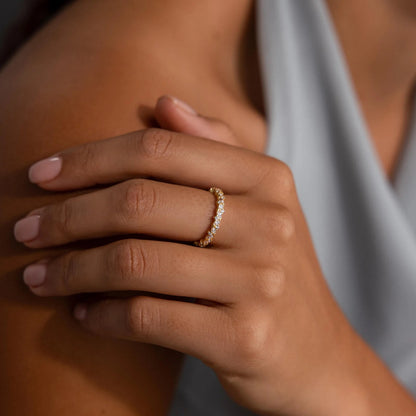 Close-up of a hand wearing a gold ring with a blurred background