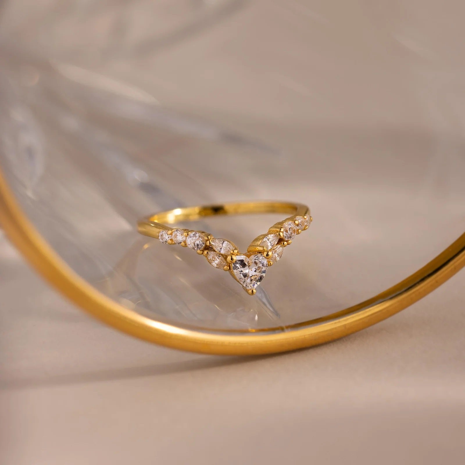 Gold ring with diamond accents on a reflective surface