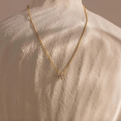 Gold necklace on a mannequin with a neutral background