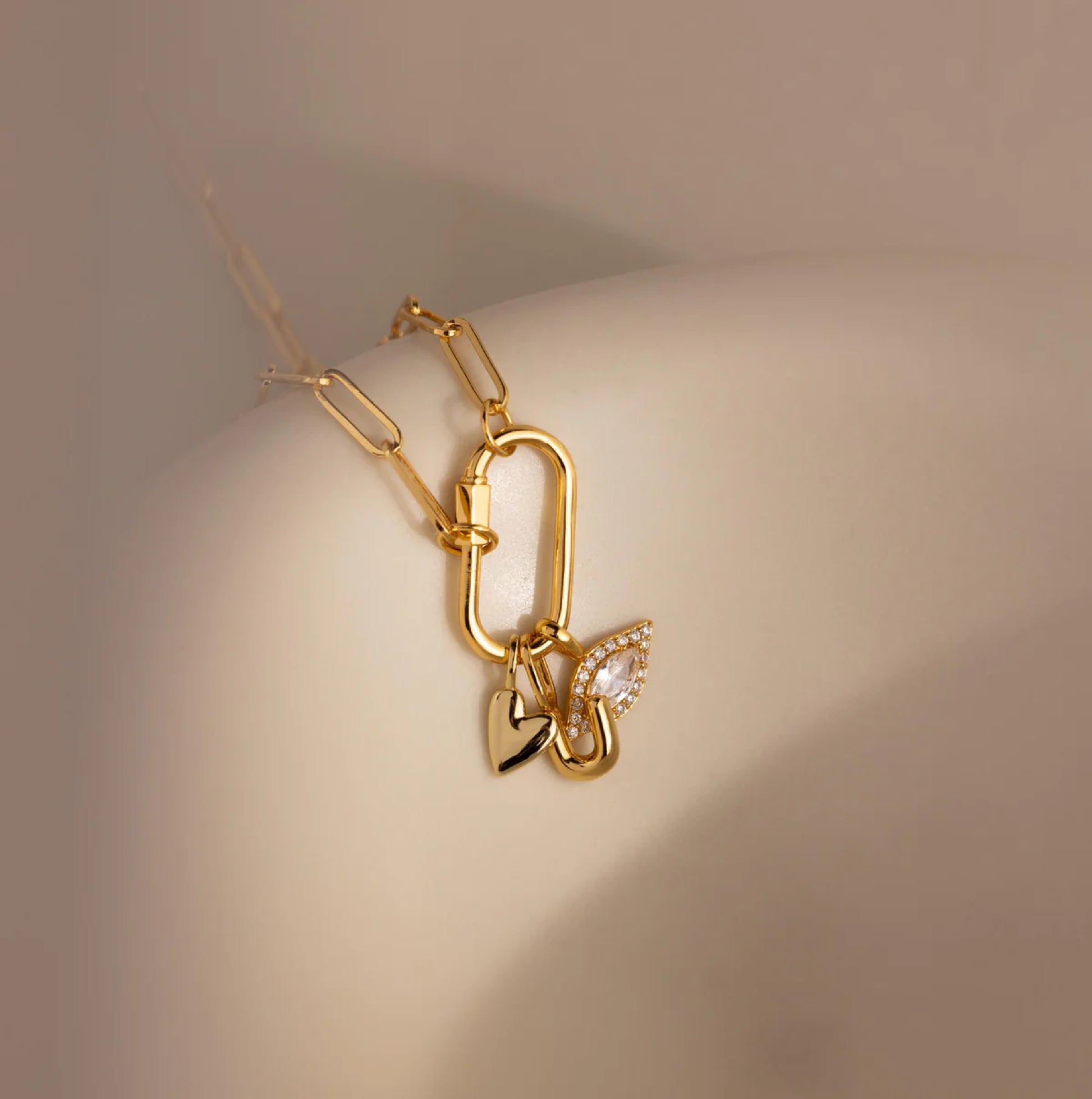 Gold bracelet with a butterfly charm on a neutral background