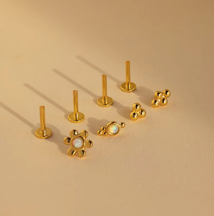 Collection of gold earrings on a beige background