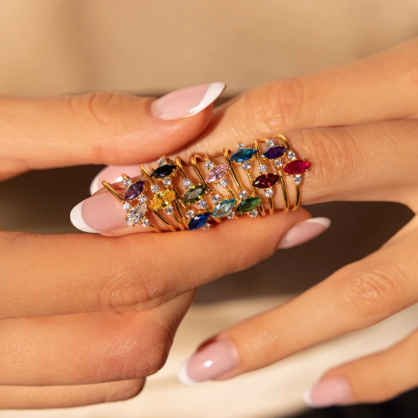 Multicolored gemstone ring on a hand with a neutral background