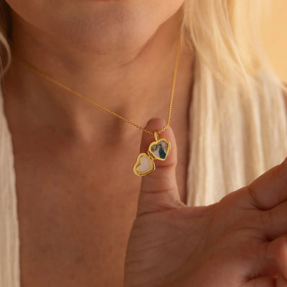 Gold necklace with a heart-shaped locket worn by a person