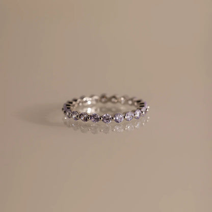 Silver ring with small diamonds on a beige background