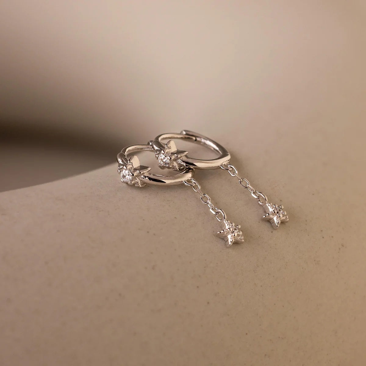 Silver ring with star-shaped stones on a beige background