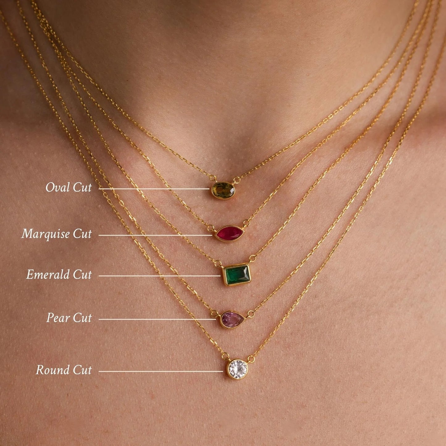 Gold necklaces with different cut gemstones on a skin background
