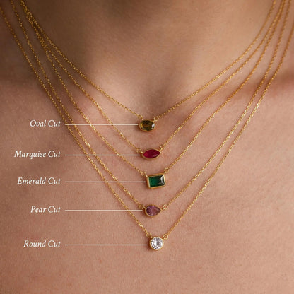 Gold necklaces with different cut gemstones on a skin background
