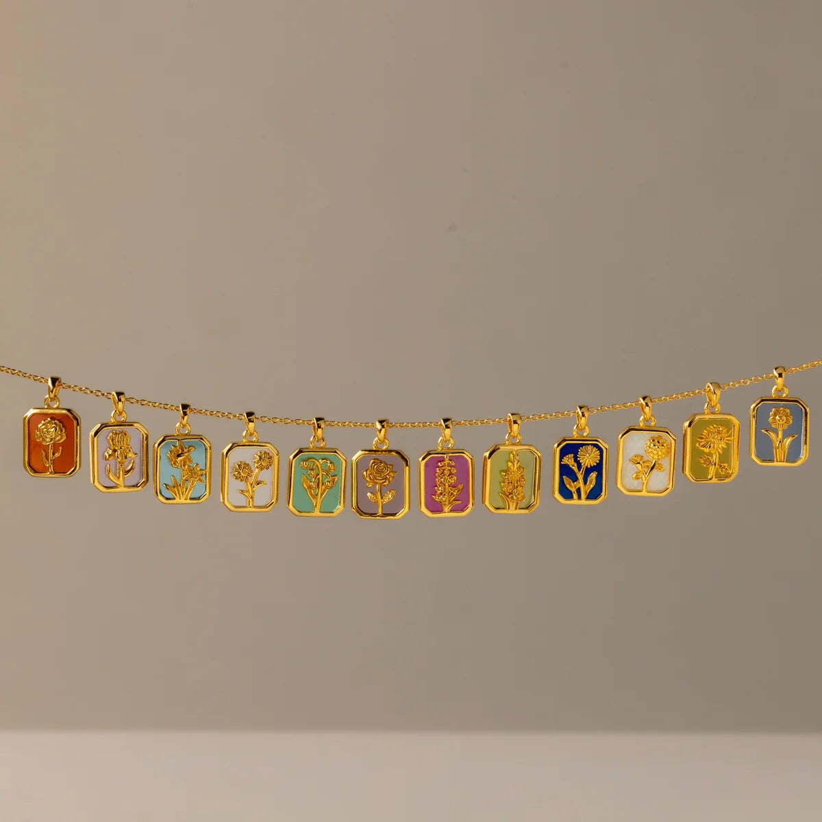 Gold necklace with various pendants on a plain background