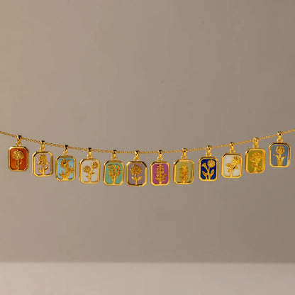 Gold necklace with various pendants on a plain background