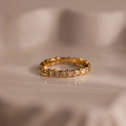 Gold ring with diamonds on a beige fabric background