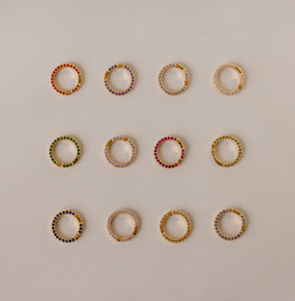 Set of multicolored hoop earrings on a light gray background